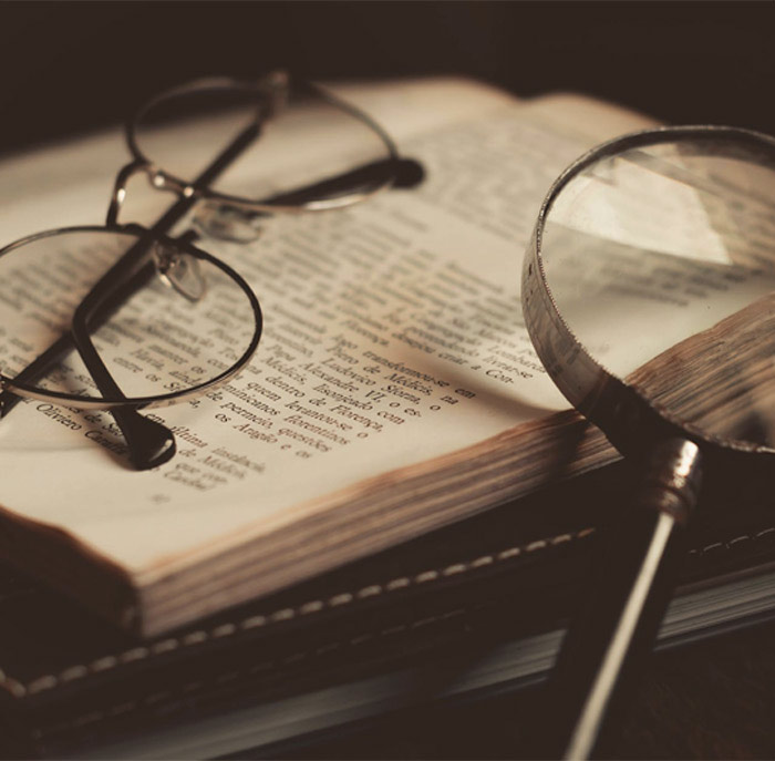 Book under glasses and magnifier 