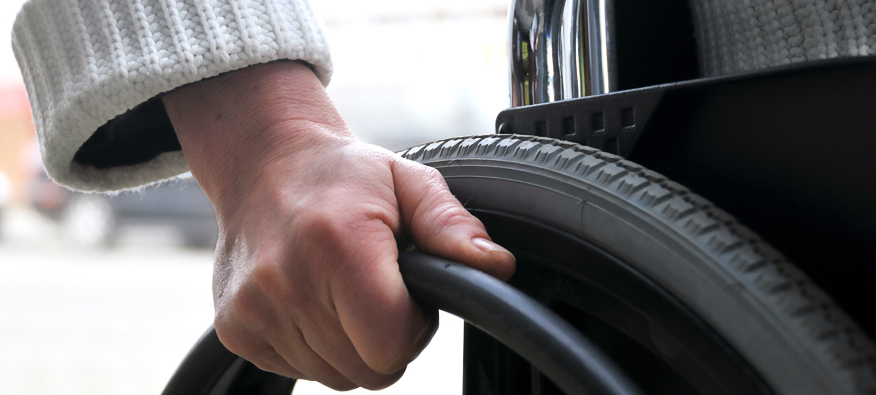 person's hand on wheelchair rim