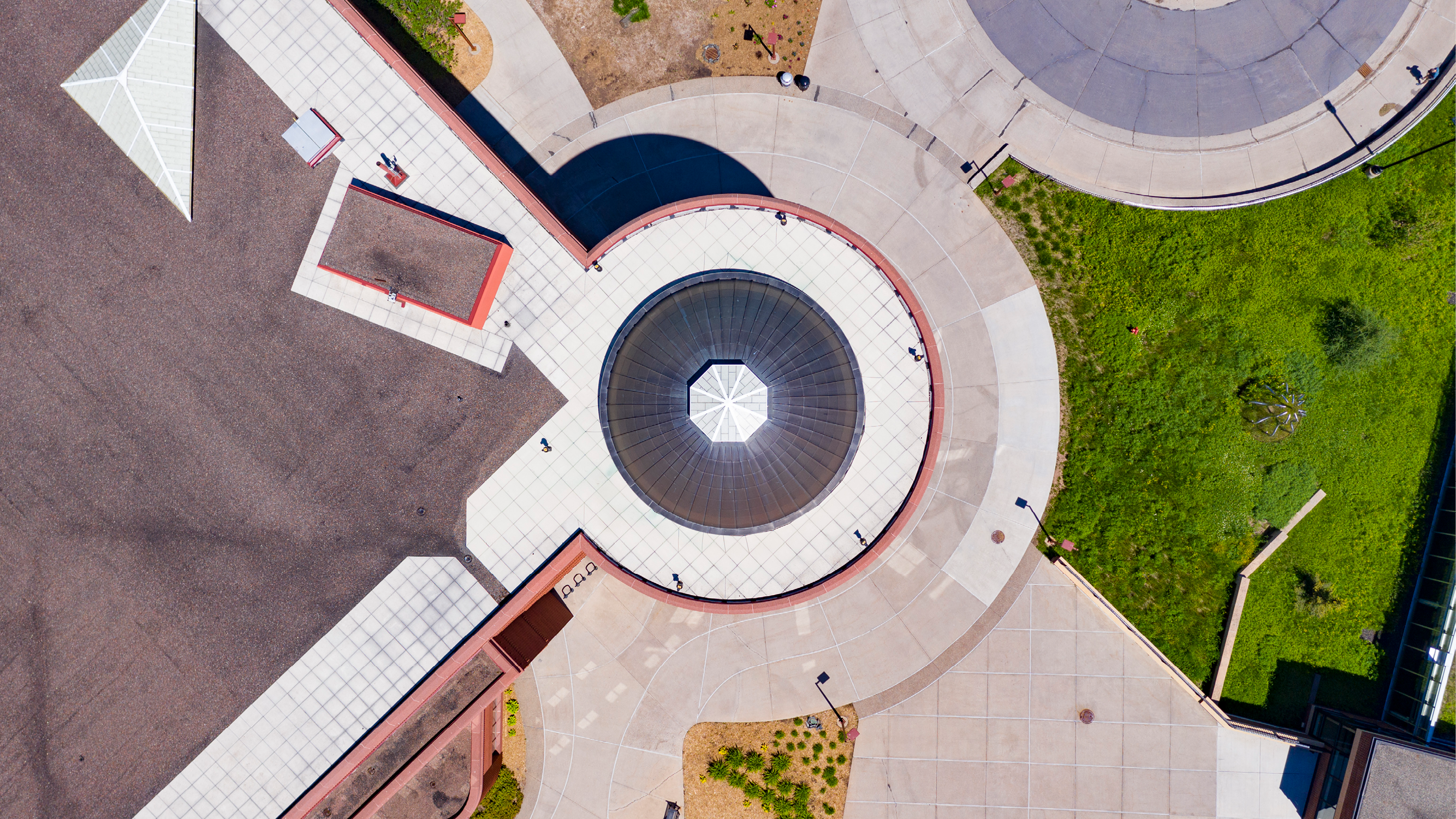 a drone photograph shows the library and surrounding landscape from a birds eye view, the image has a very abstract appearance. 
