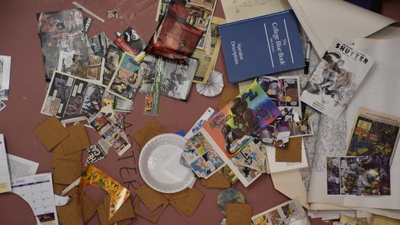 overhead view of a crafting table strewn with glue, art and materials
