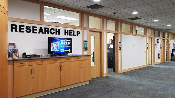 a sign that says "research help" next to a wall of offices