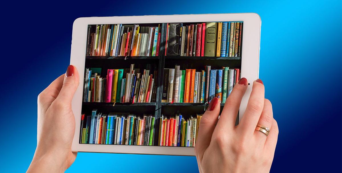hands of a woman holding an ipad. books spines on a shelf are displayed on the ipad
