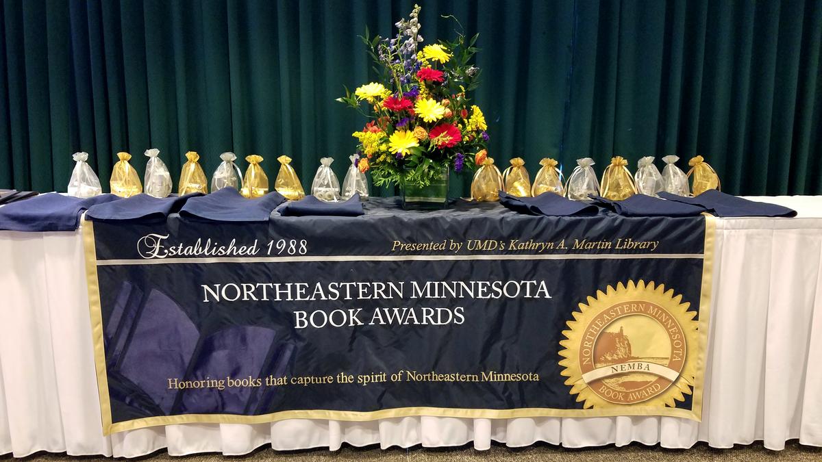 northeastern minnesota book awards table with banner, flowers and awards