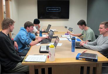 students using a library group study room with TV monitor