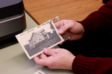 Tucker Nelson holds an old photograph of a Duluth Home. 