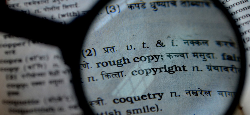 Magnifying glass over the word copyright in a dictionary